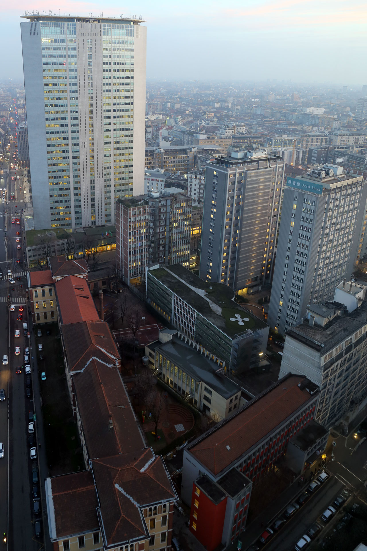Il Pirellone al crepuscolo visto dall'alto, con i tetti del quartiere circostante.
