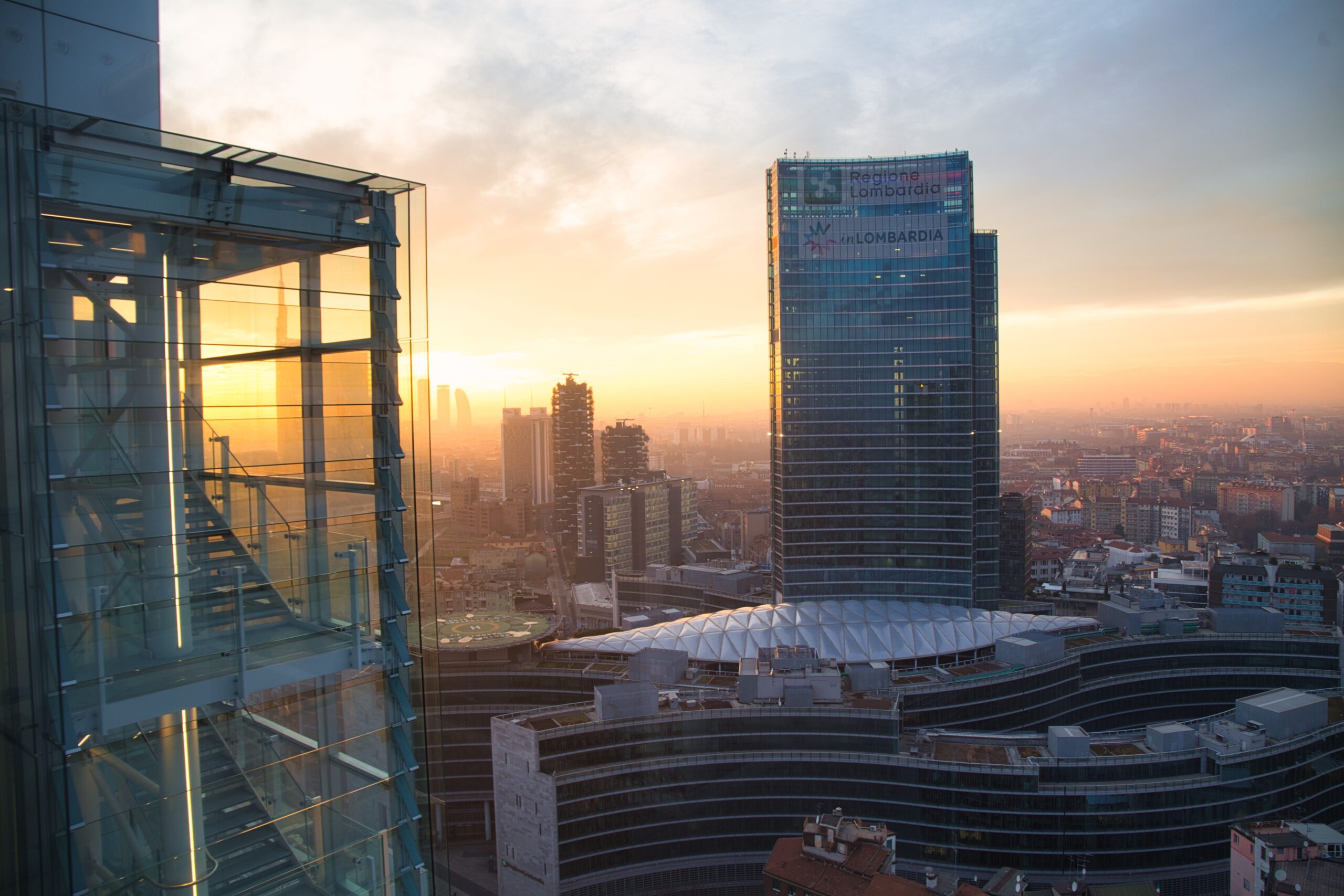 Palazzo Lombardia al tramonto, vista da lontano con le insegne Regione Lombardia e inLombardia.