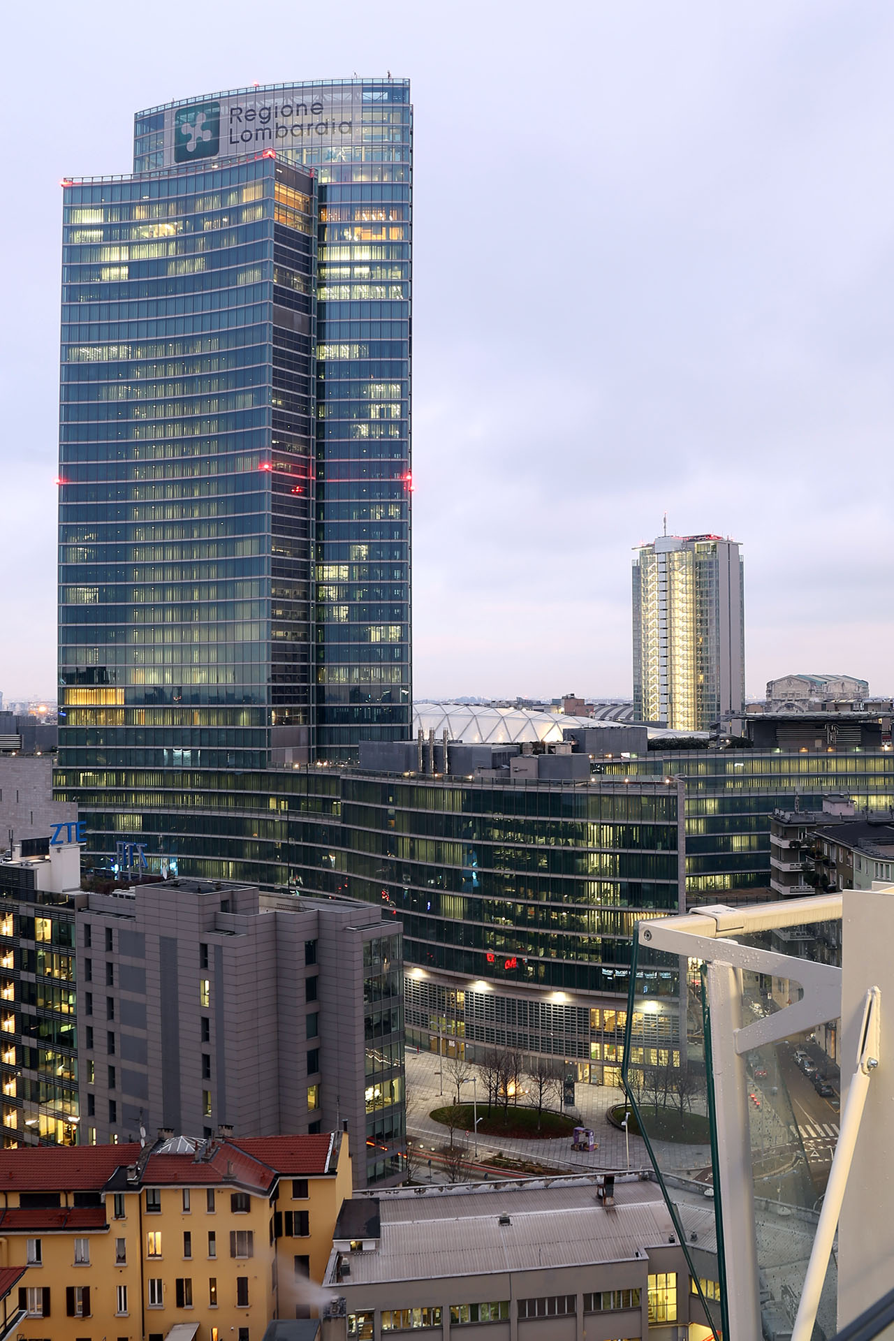 Palazzo Lombardia al blue hour, con le luci di segnalazione aerea rosse sulla facciata.