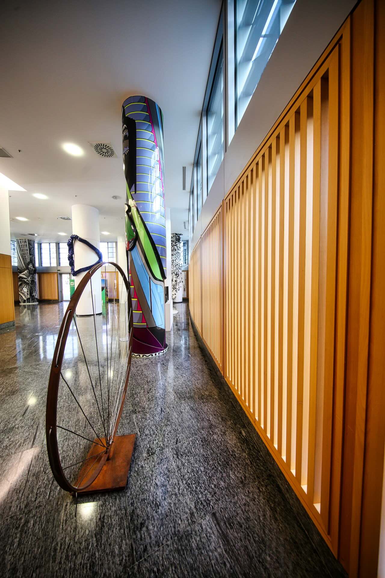 Un'altra vista della hall, con un'installazione scultorea a forma di ruota di bicicletta.