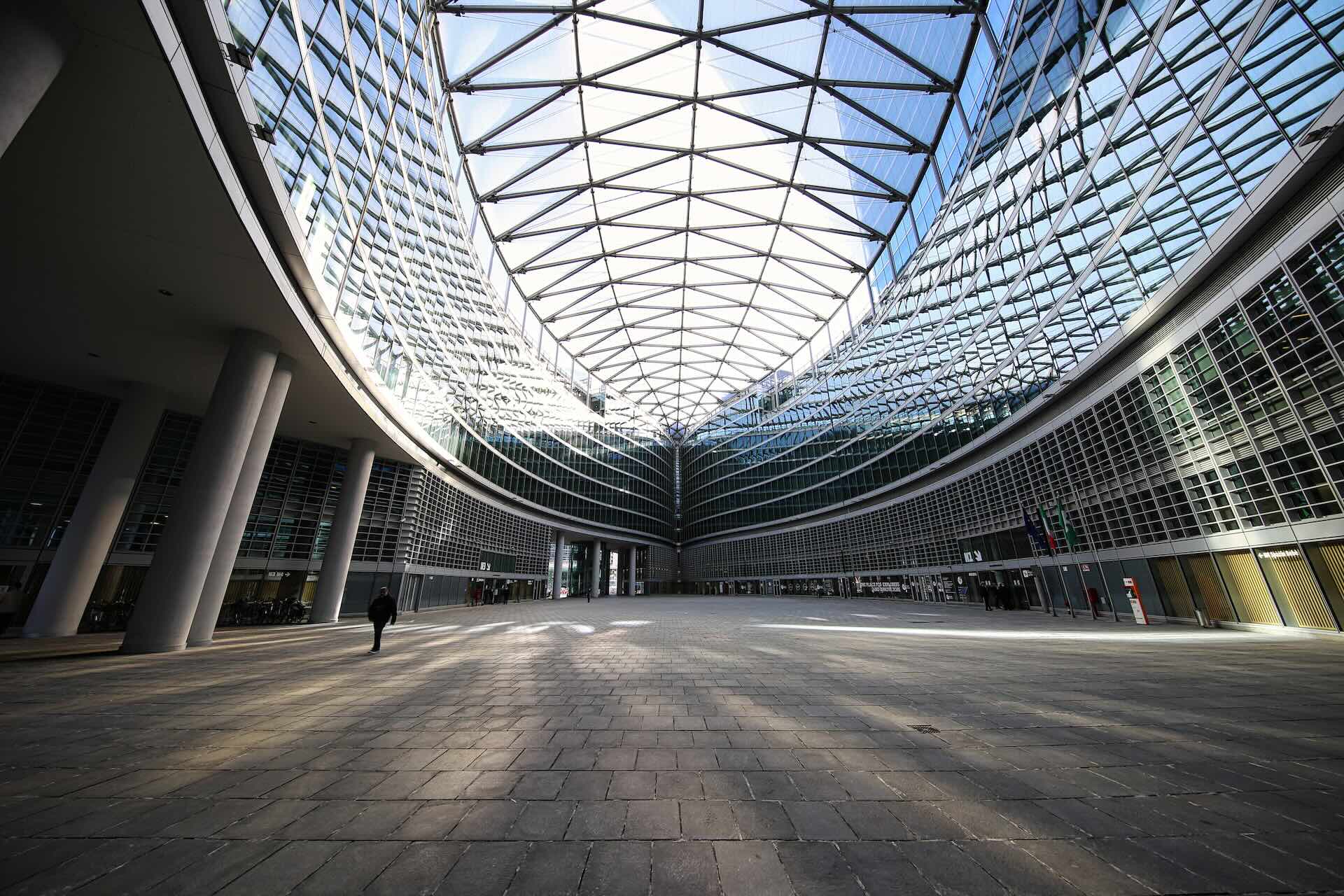 La grande piazza coperta in vetro alla base di Palazzo Lombardia, vista dal livello del suolo.