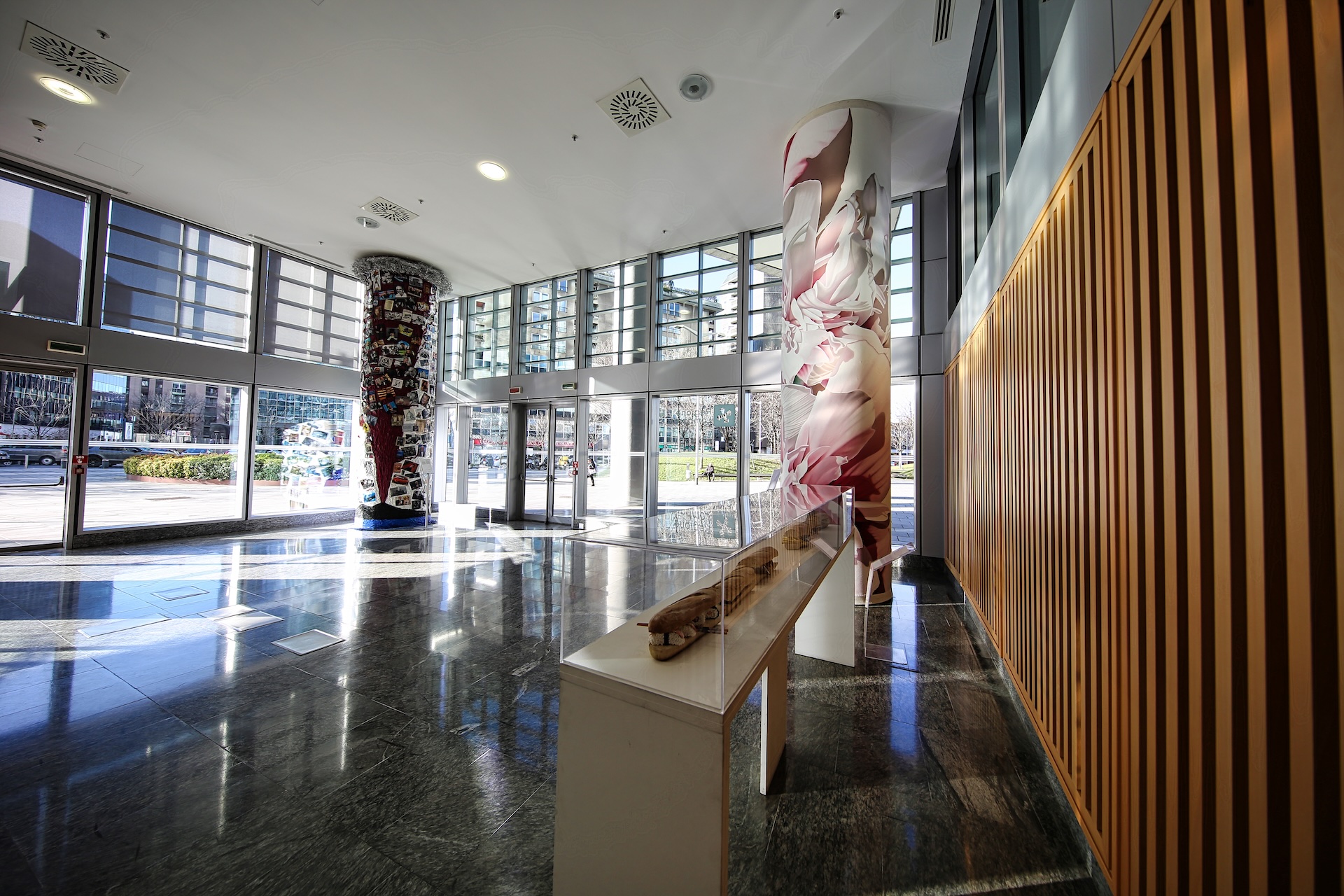 La hall interna di Palazzo Lombardia, con installazioni artistiche sulle colonne.