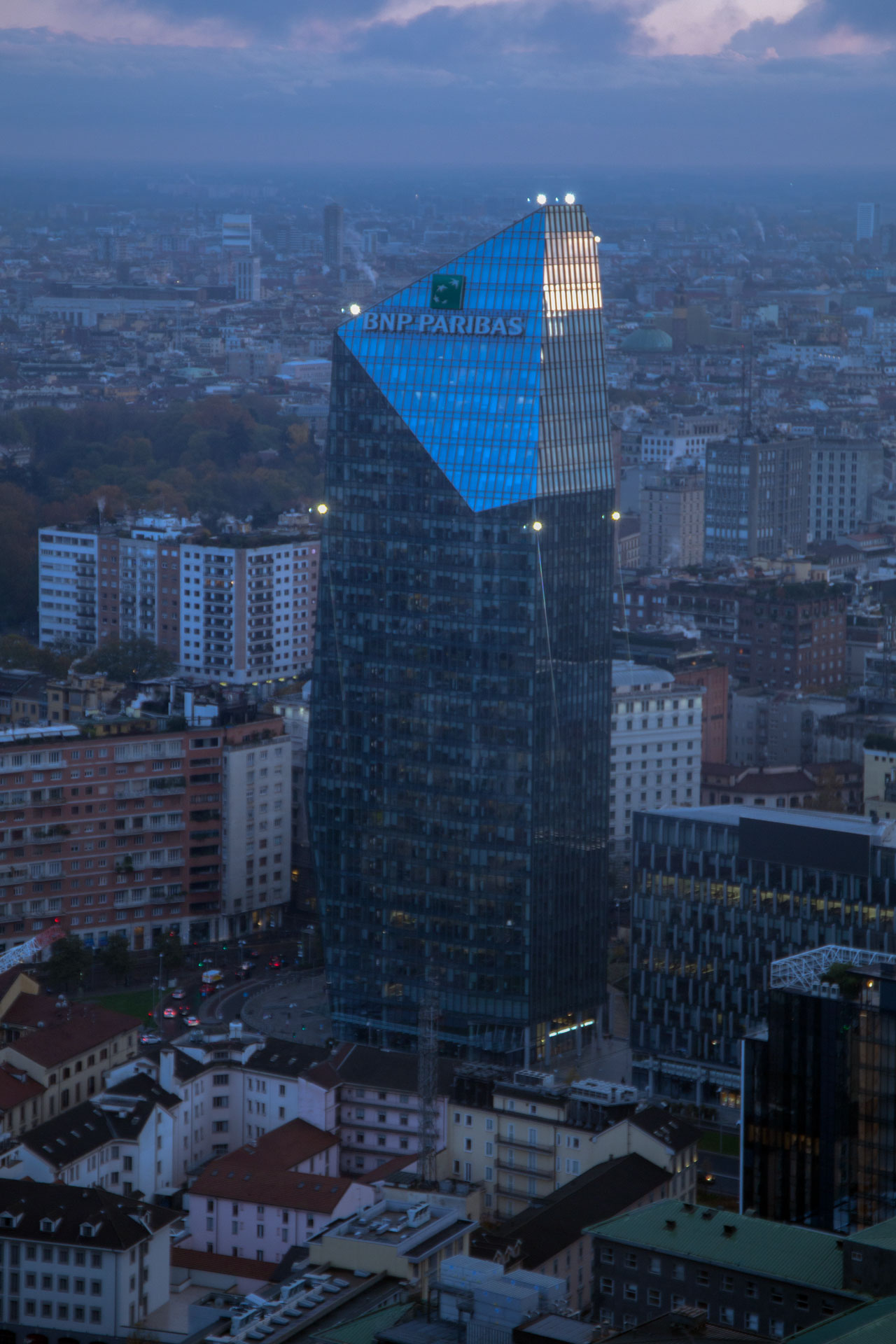 La sommità sfaccettata della Torre Diamante al crepuscolo, avvolta nella foschia.