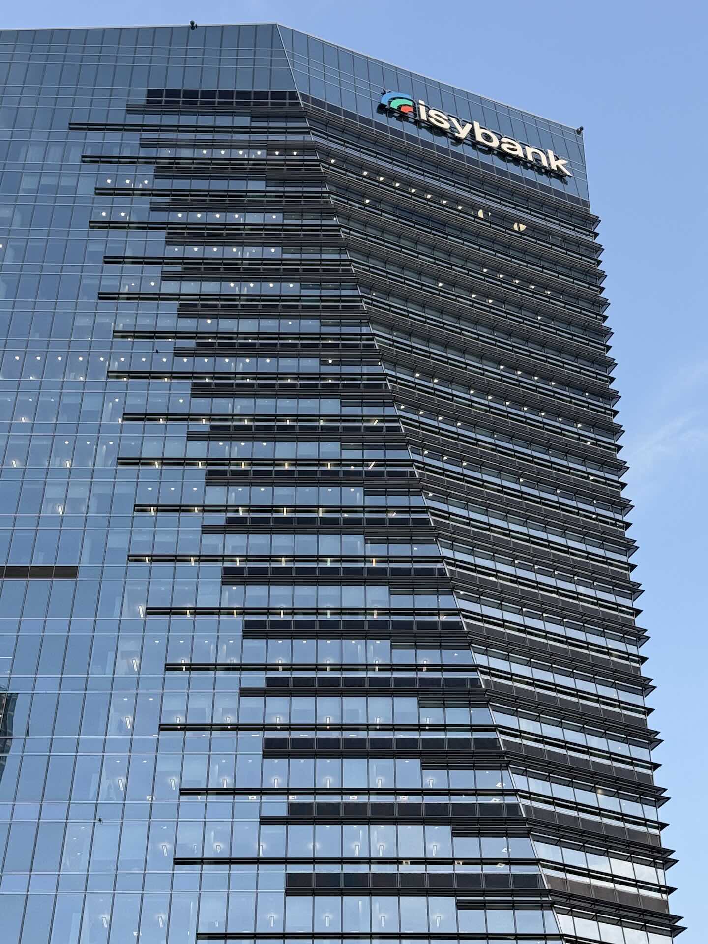 Dettaglio della facciata a lama di vetro della Torre Gioia 22, con il logo isybank.