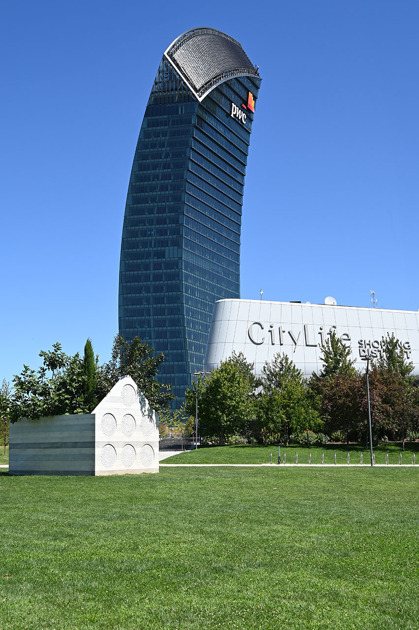 La Torre PwC vista per intero, con l'ingresso del CityLife Shopping District e un'opera d'arte in primo piano.