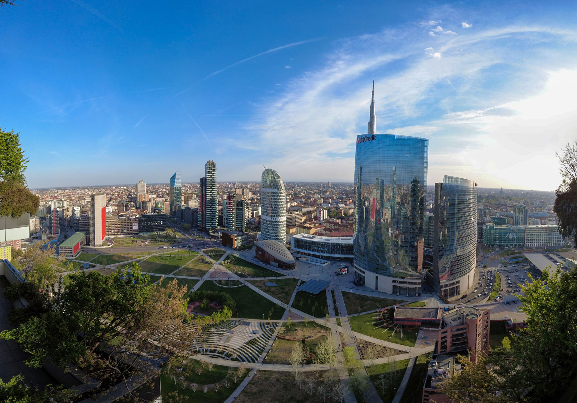 Vista fisheye dall'alto di Piazza Gae Aulenti e del parco Biblioteca degli Alberi, con la Torre Unicredit al centro.
