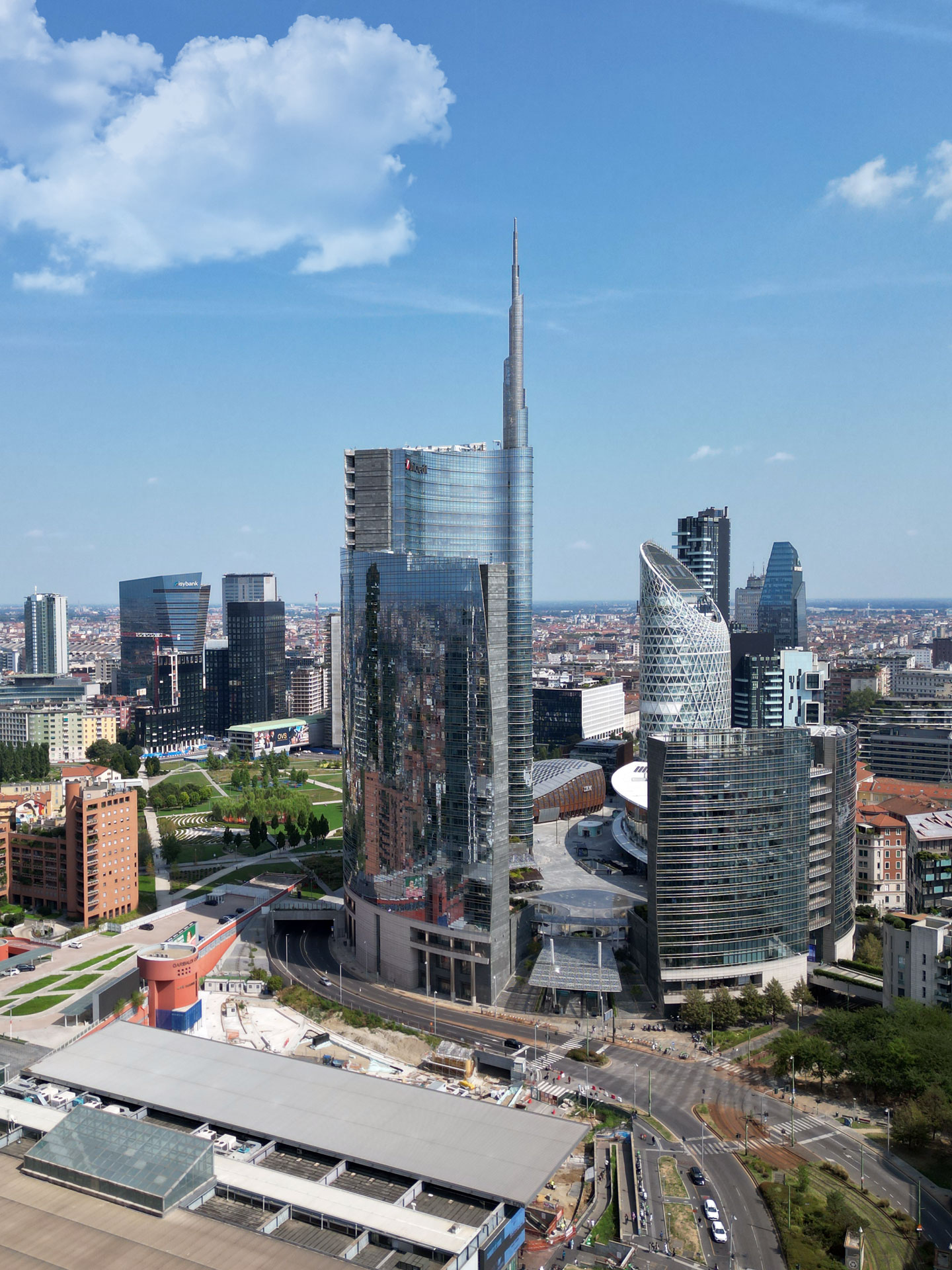 Vista aerea diurna della Torre Unicredit con il parco Biblioteca degli Alberi e lo skyline di Porta Nuova.