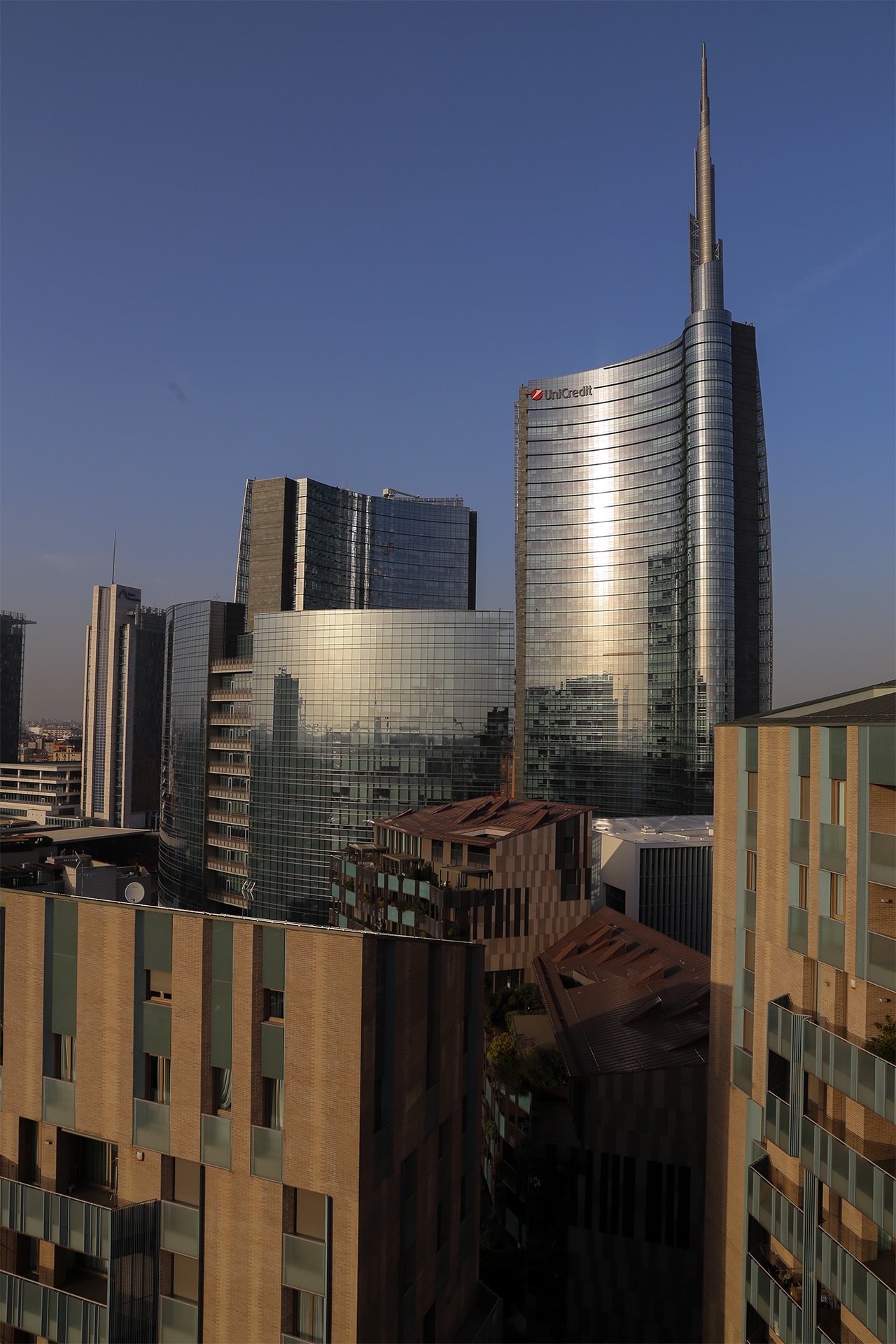 La Torre Unicredit al tramonto dorato, vista tra i palazzi residenziali di Porta Nuova.