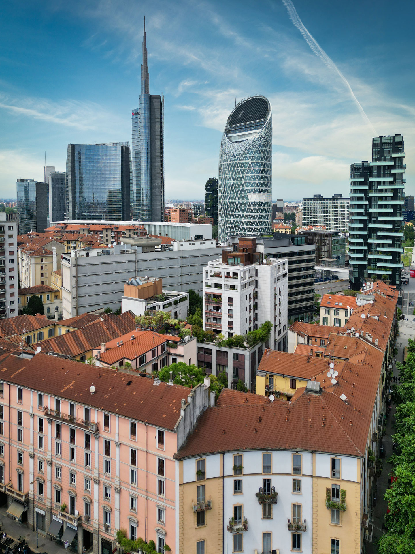 Vista dai tetti del centro storico milanese verso la Torre Unipol, con la Torre Unicredit e il Bosco Verticale sullo sfondo.