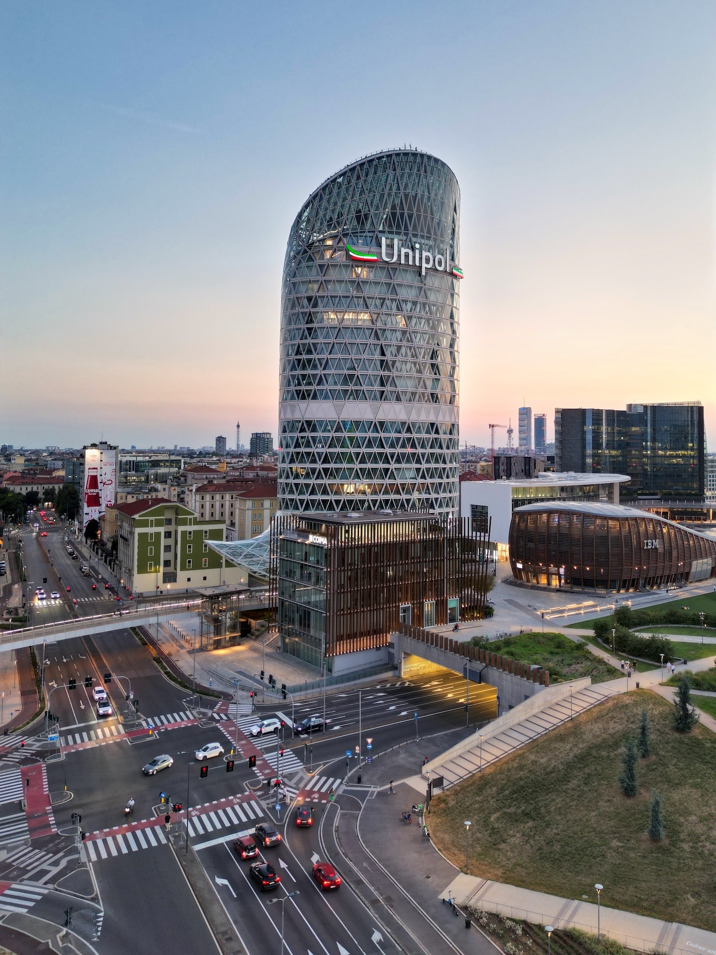 La Torre Unipol al tramonto, con il logo Unipol ben visibile e l'edificio IBM Studios sullo sfondo.