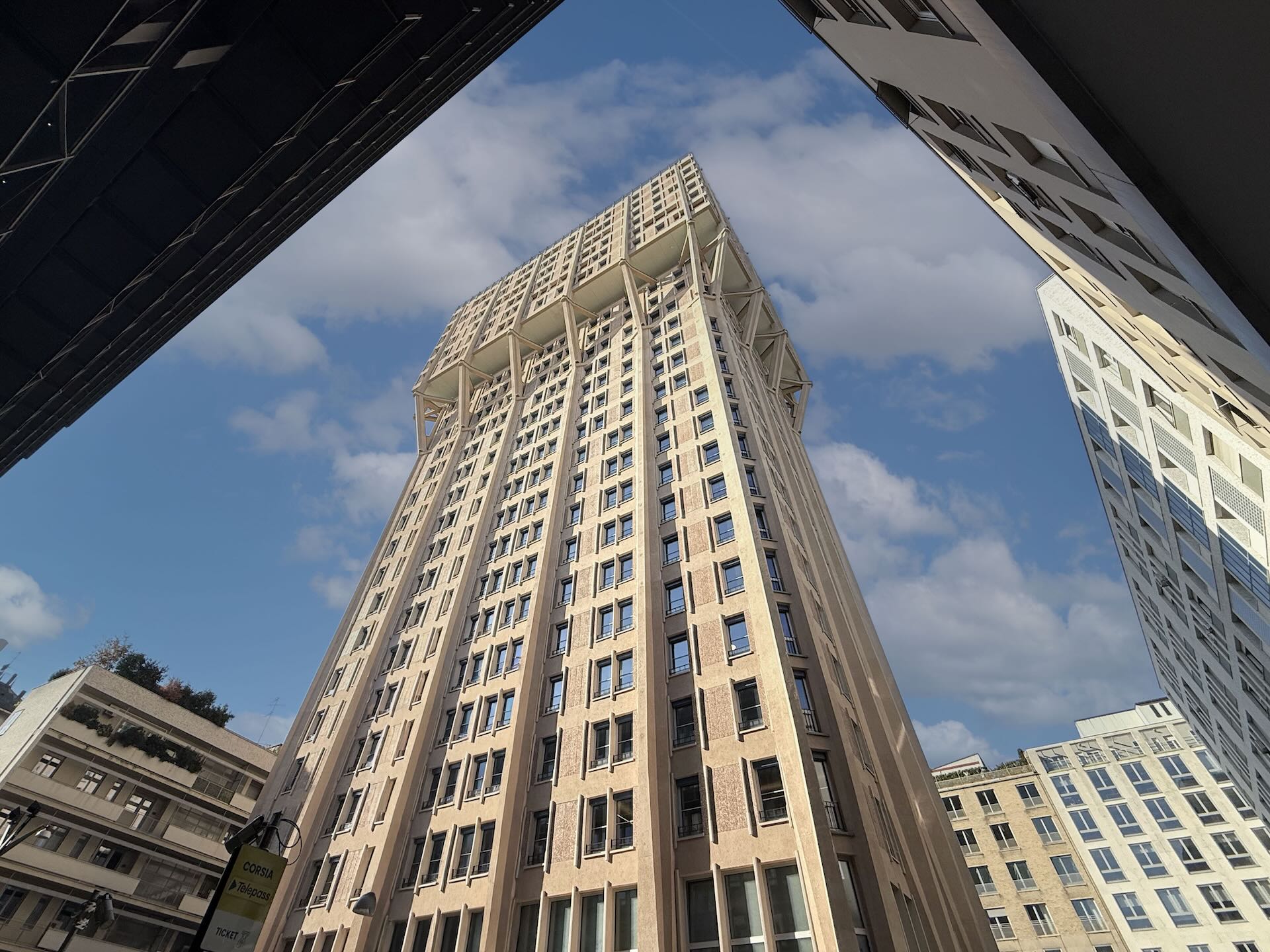La sommità 'a fungo' della Torre Velasca, con le mensole strutturali (le 'bretelle') contro il cielo blu.