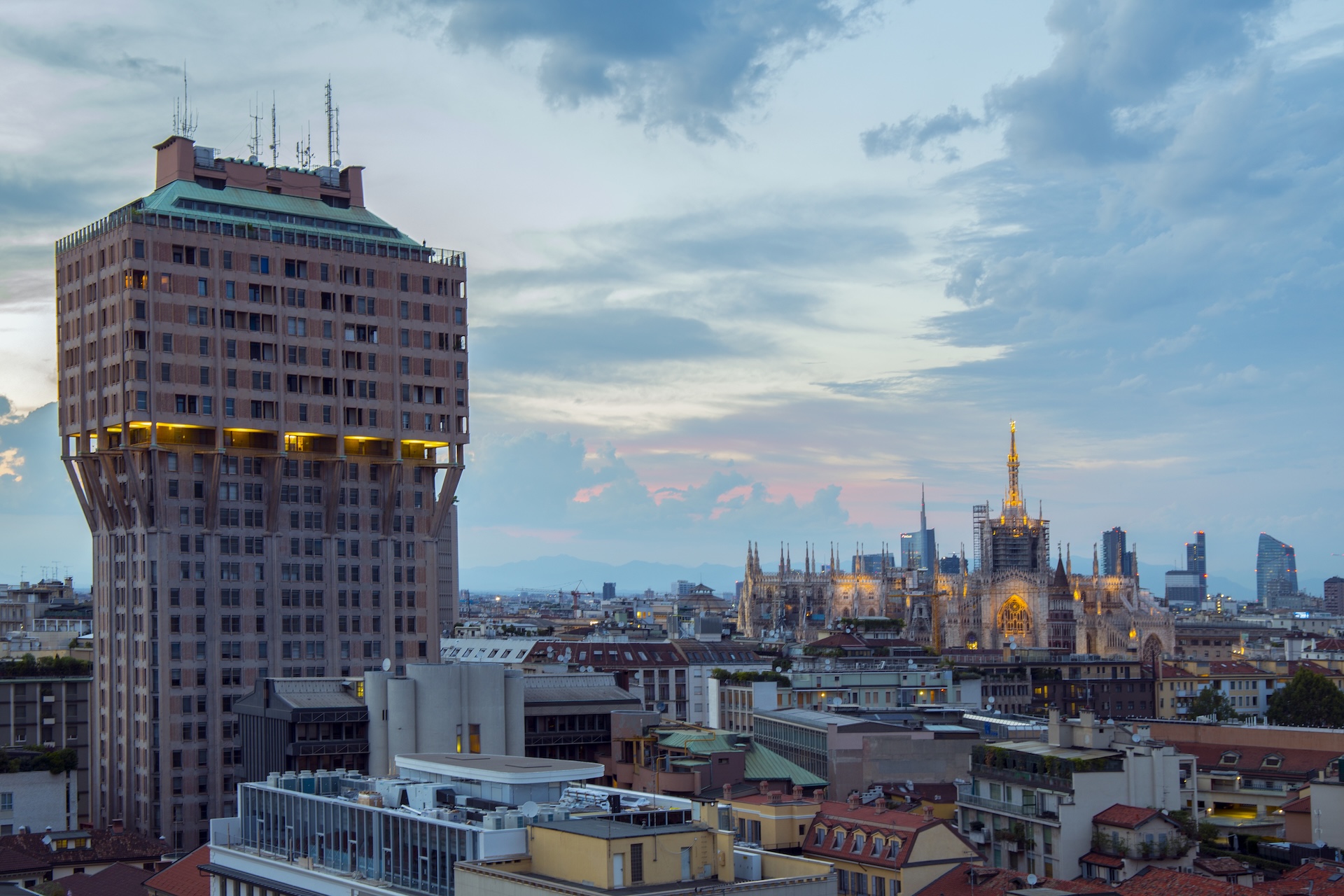 La Torre Velasca al crepuscolo, in dialogo con le guglie del Duomo di Milano sullo sfondo.