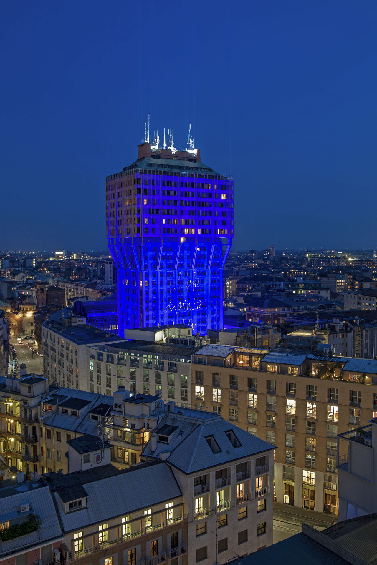 La Torre Velasca illuminata di blu per il progetto Urban Up – Unipol durante la Design Week 2019, con una scritta luminosa proiettata sulla facciata.