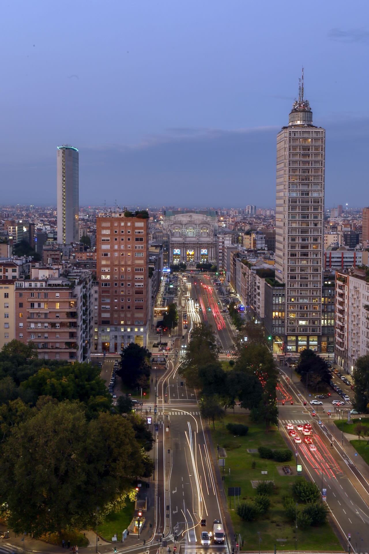 Torre Breda al blue hour, con le scie di luce del traffico lungo Via Vittor Pisani verso Stazione Centrale.