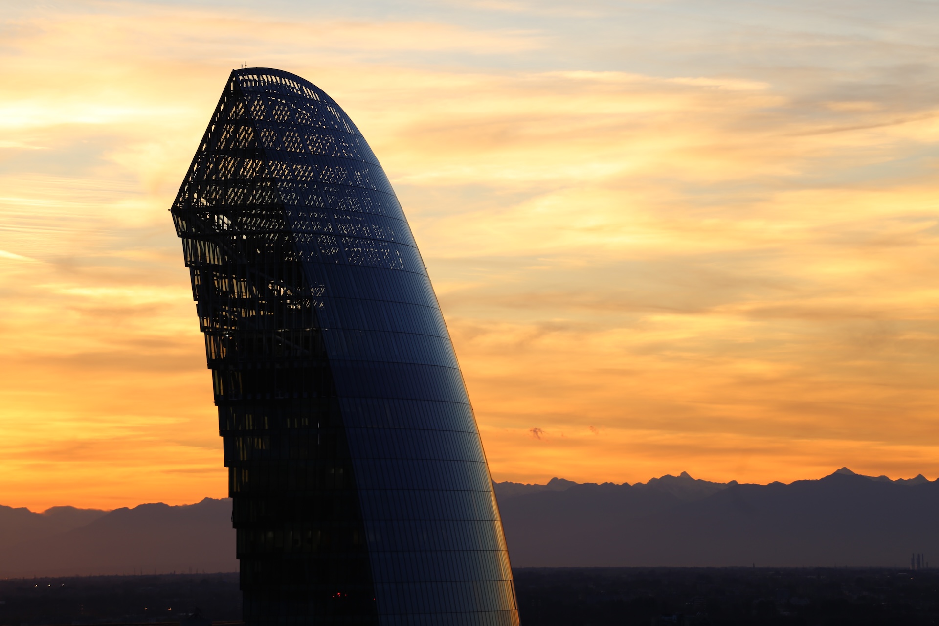 La sommità della Torre Hadid stagliata contro un tramonto arancione acceso.